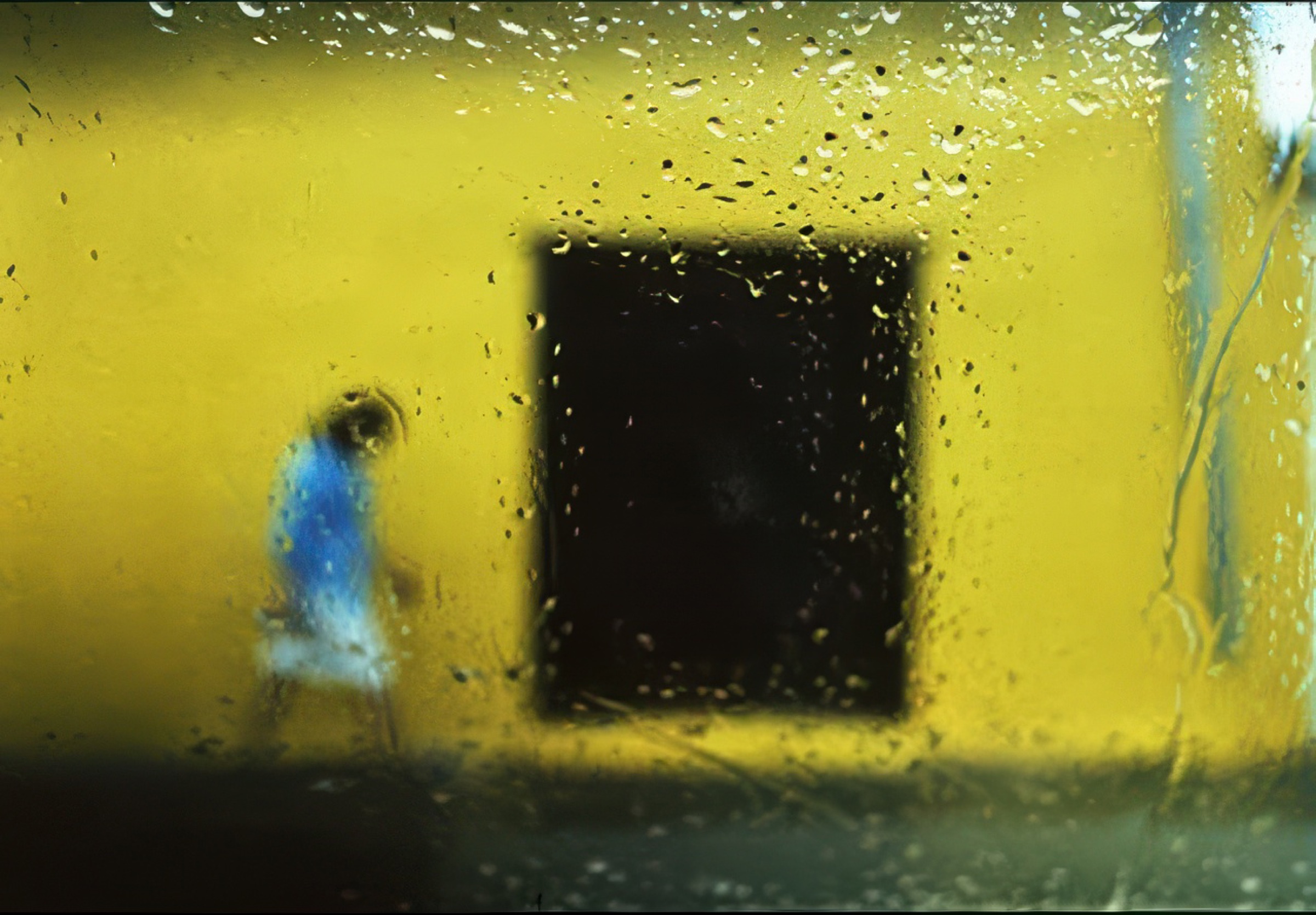 Child running past a yellow wall